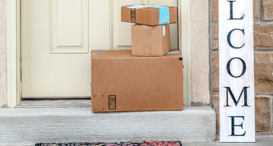 Packages on the doorstep of a home with a welcome sign in St. Petersburg